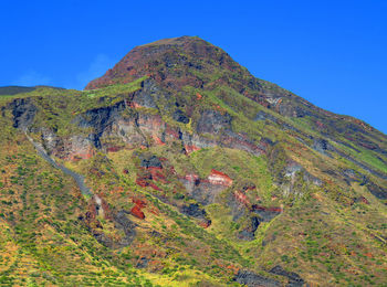 Low angle view of mountain against clear blue sky