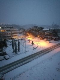 Snow covered road against sky at night