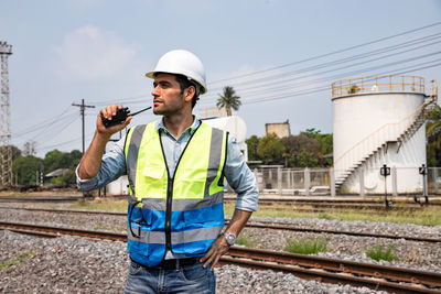 Man working on railroad tracks against sky