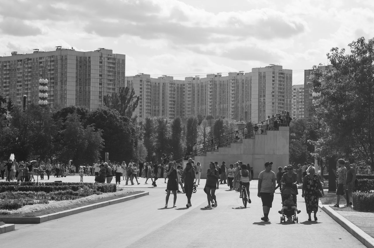 group of people, architecture, crowd, building exterior, city, real people, large group of people, built structure, sky, tree, men, street, day, nature, building, plant, walking, women, outdoors, office building exterior, skyscraper