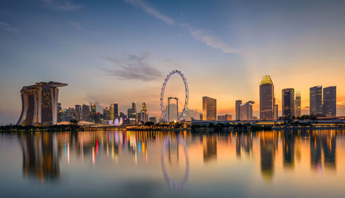 Reflection of buildings in city at sunset