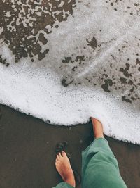 Low section of person standing on beach
