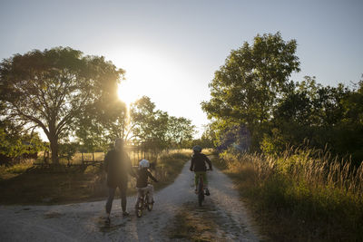 Mother teaching kid to ride bicycle on dirt road