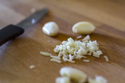 Garlic cloves and chopped garlic on wooden board