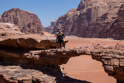 Rear view of man on rocks against mountains