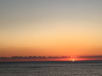 Scenic view of sea against orange sky