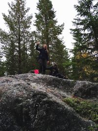 Full length of woman standing on tree trunk