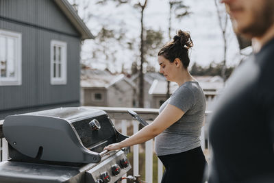 Woman on balcony grilling food