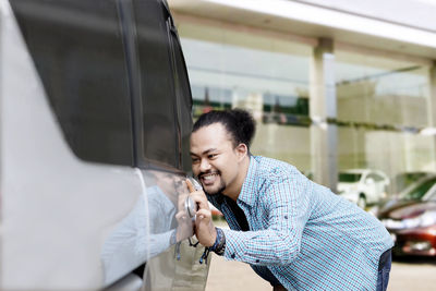 Young man standing in car