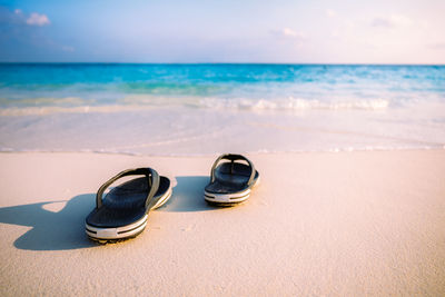 High angle view of flip-flops on beach against sea