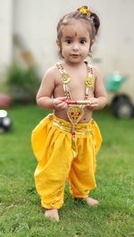 Portrait of cute girl standing on field