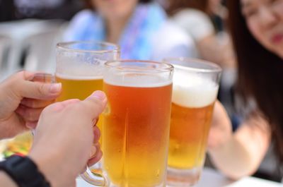 Cropped image of people holding beer mugs