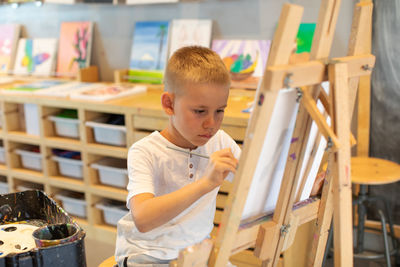 Boy painting at classroom