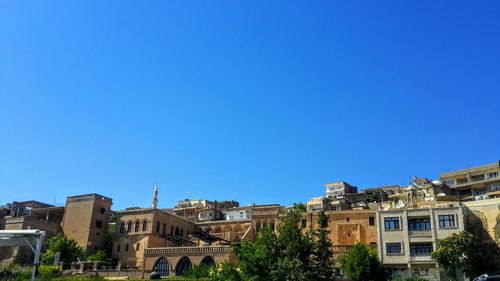 Houses in town against clear blue sky