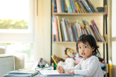 Portrait of girl sitting on table