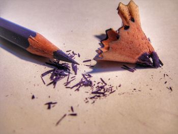 Close-up of colored pencil with shavings on table