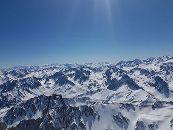 Scenic view of snowcapped mountains against clear blue sky