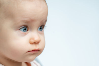 Close-up of cute baby boy against white background