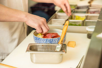 Midsection of man preparing food in kitchen at home