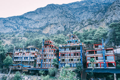 Buildings by mountains against sky