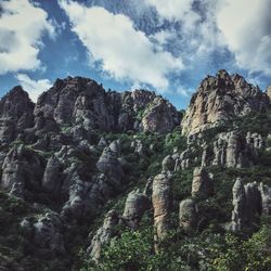 Low angle view of rocky mountains against sky