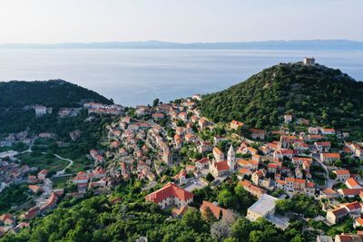 High angle view of townscape by sea against sky