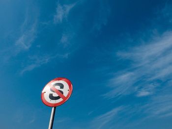 Low angle view of road sign against blue sky