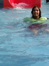 Portrait of a smiling young woman swimming in pool