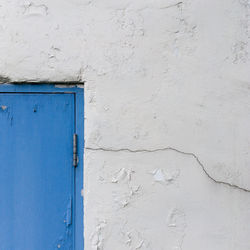 Close-up of white wall and blue door