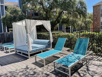 Empty chairs by swimming pool in yard