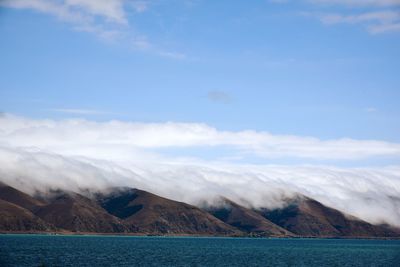 Scenic view of sea and mountains against sky