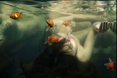 Shirtless woman in aquarium