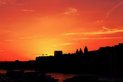 Silhouette buildings against sky during sunset