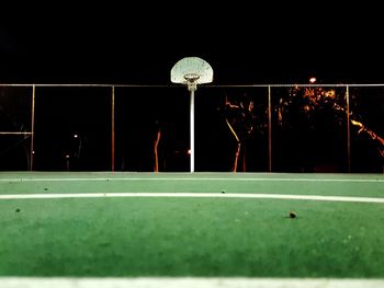 People playing soccer ball against sky at night