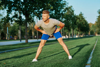 Full length of young man exercising on field