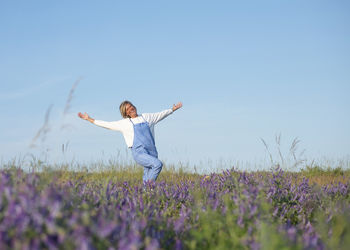 Rear view of woman standing on field against clear sky