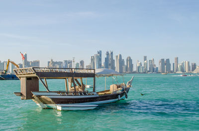 Ship in sea against buildings in city