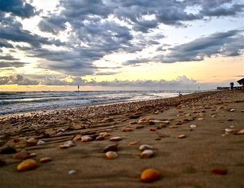 Scenic view of beach against cloudy sky