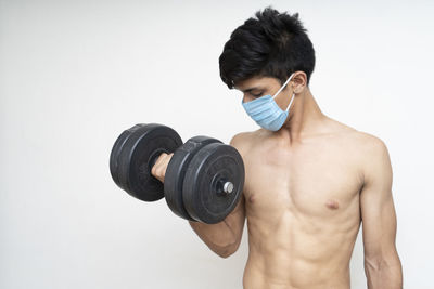 Midsection of shirtless man against white background