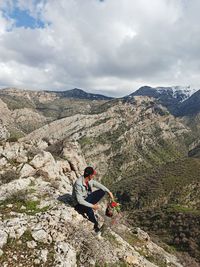 Person on rock against sky