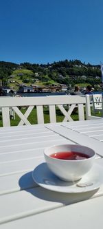 Coffee cup on table against clear sky