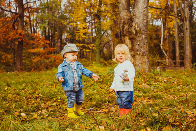 Full length of a boy with autumn trees