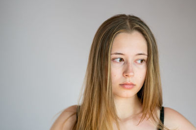 Portrait of beautiful young woman against white background