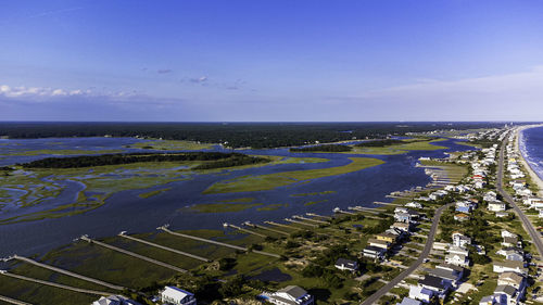 High angle view of city by sea against sky