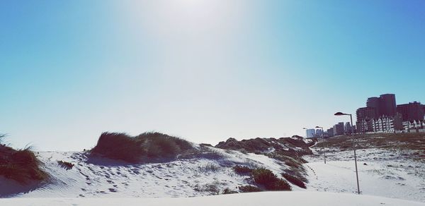 Snow covered landscape against clear sky