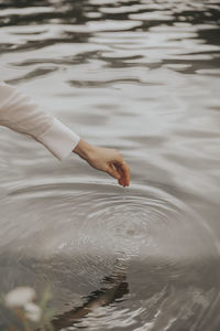 High angle view of person hand in lake