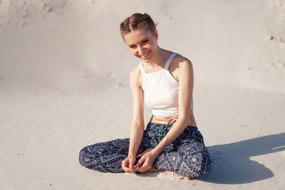 Young woman sitting on wall