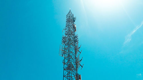 Low angle view of communications tower against blue sky