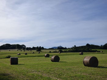 Hay bales on field against sky