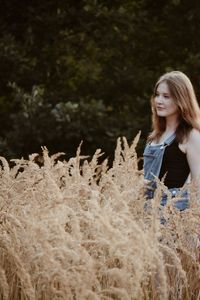 Young woman smiling while standing on field